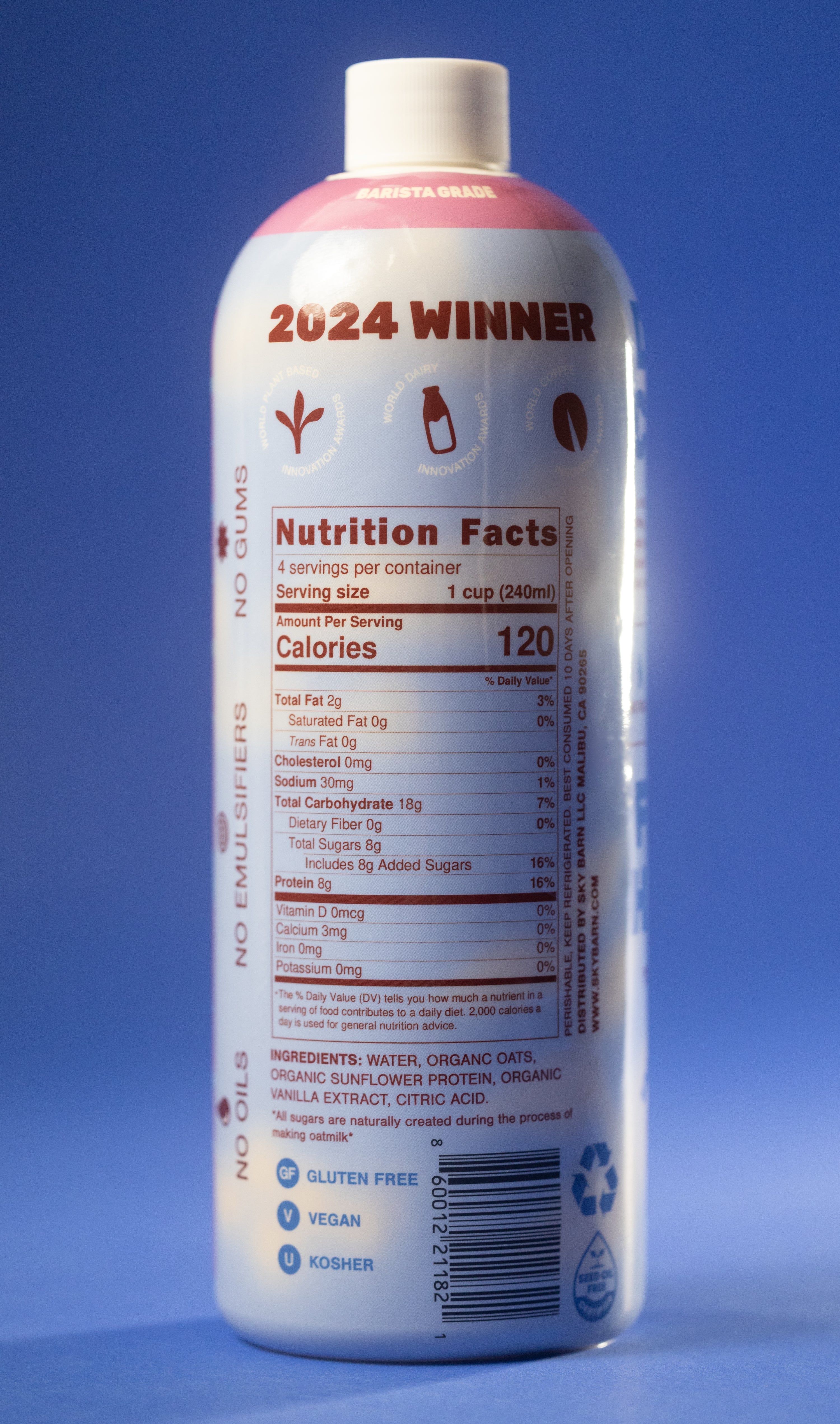 Barista grade bottle of vanilla oat milk with sunflower protein on a cloudy sky background